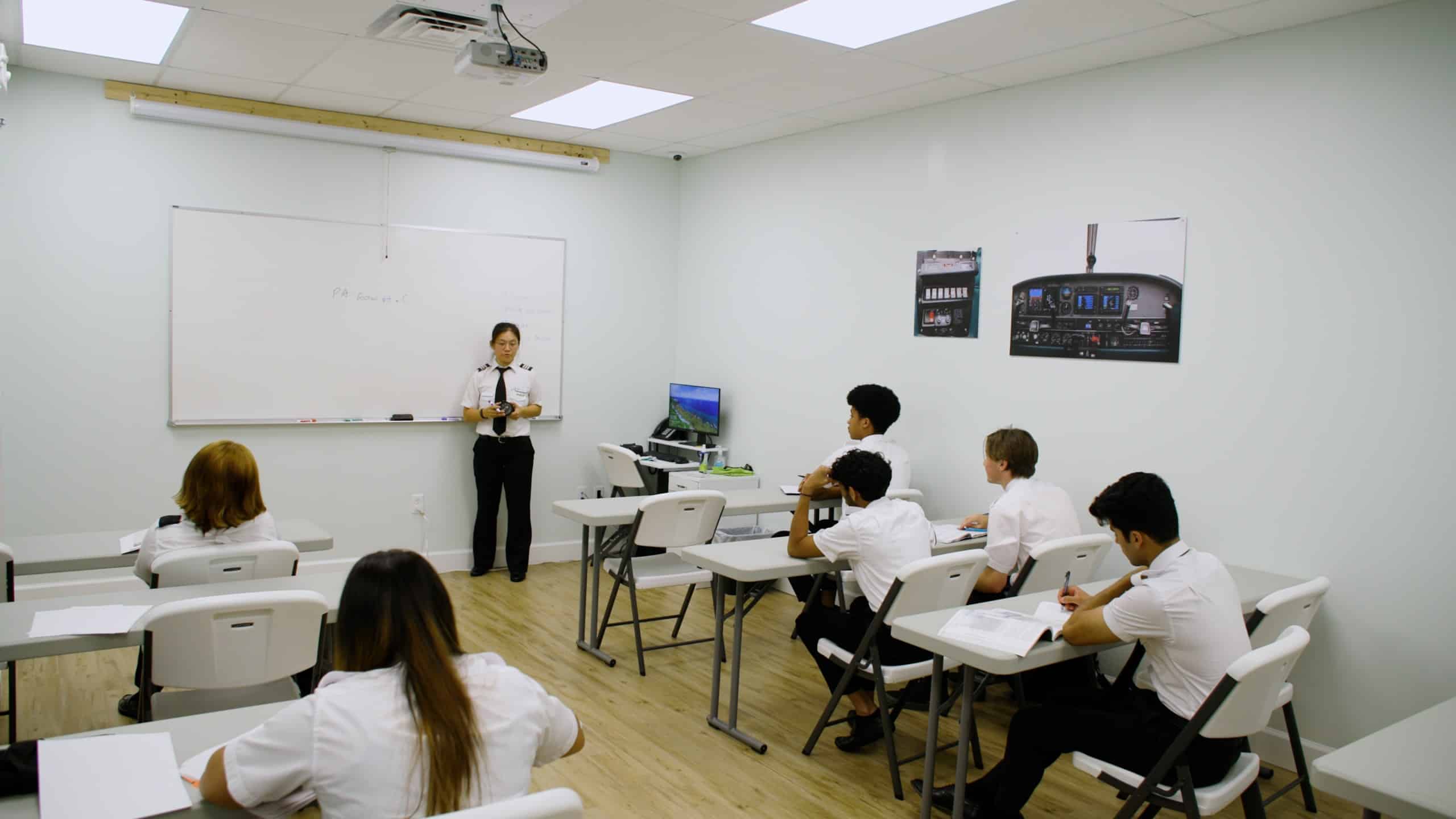 A Paris Air instructor standing in front of a classroom while students watch from their desks