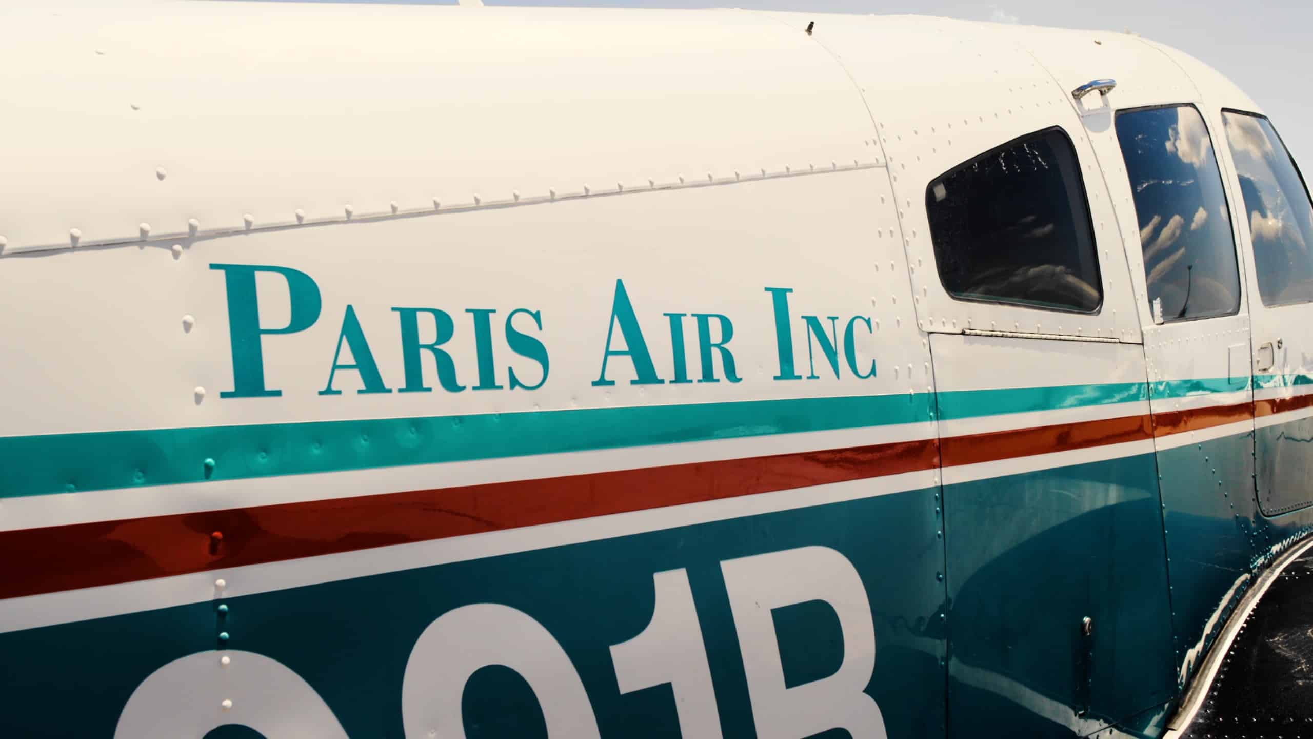 Closeup of the Paris Air Inc name on the side of a small airplane