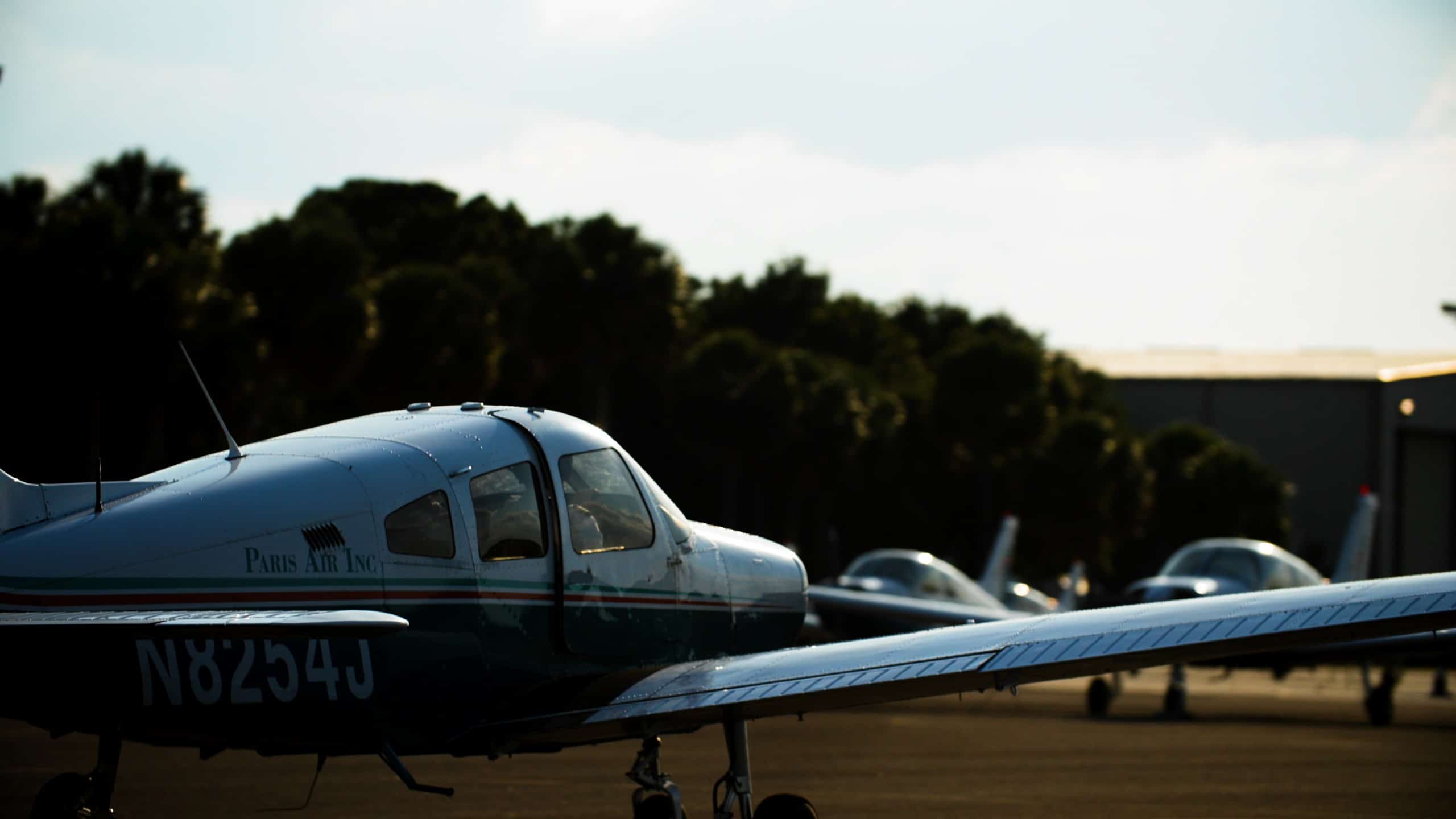A Paris Air small airplane parked on the tarmac in evening light