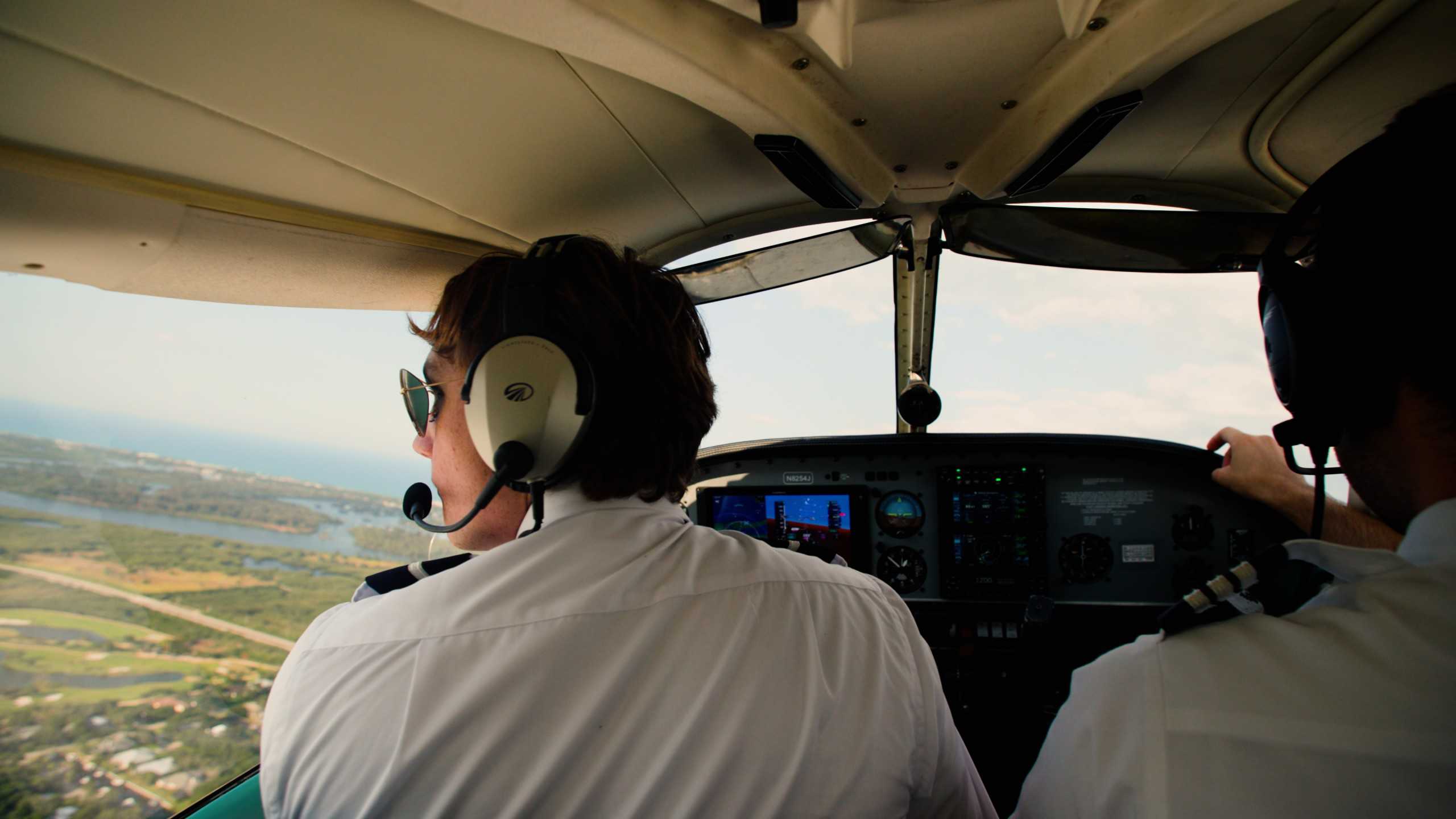 View from behind of a pilot and copilot in an airplane cockpit