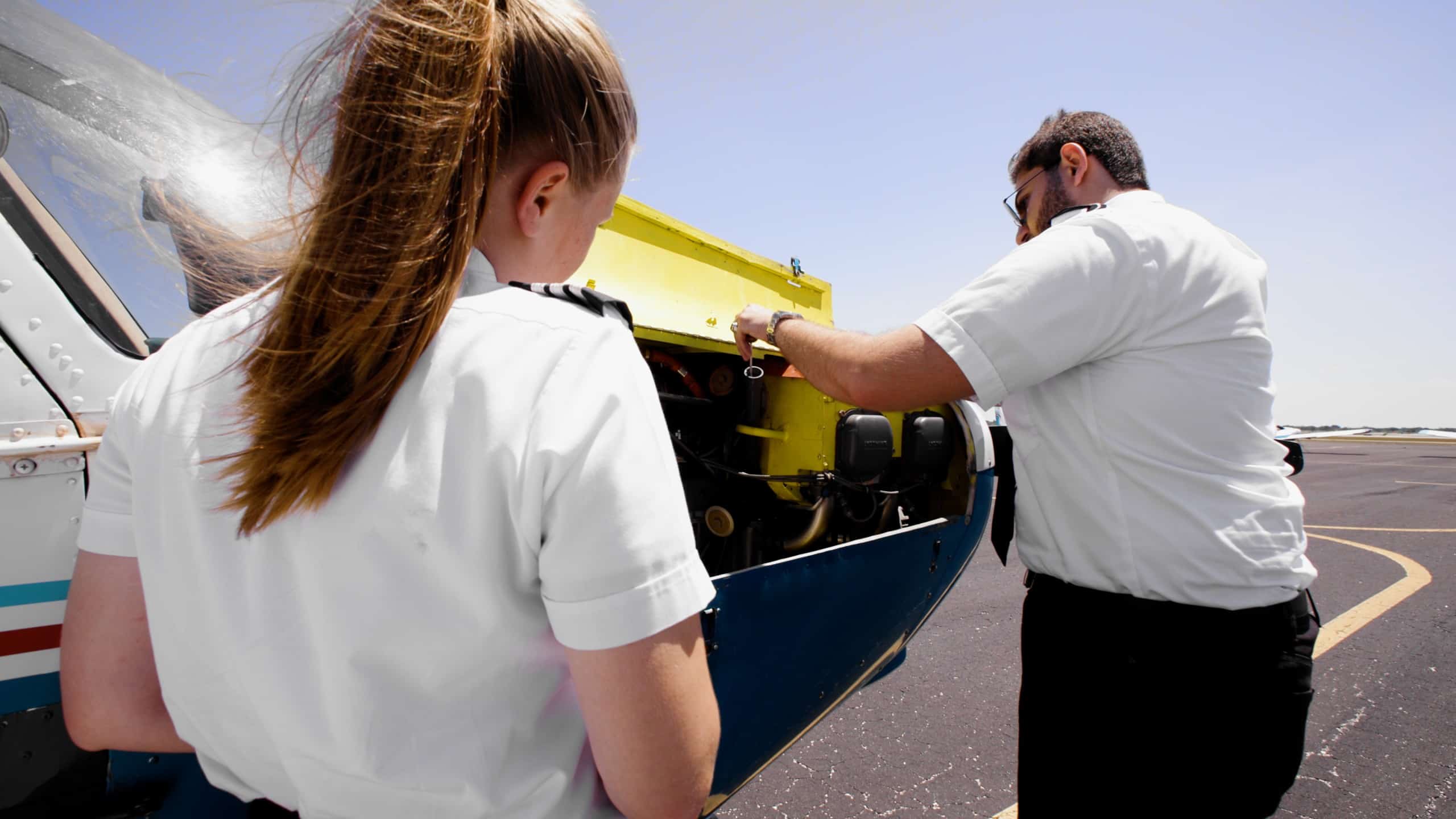 Two Paris Air flight students inspecting an airplane
