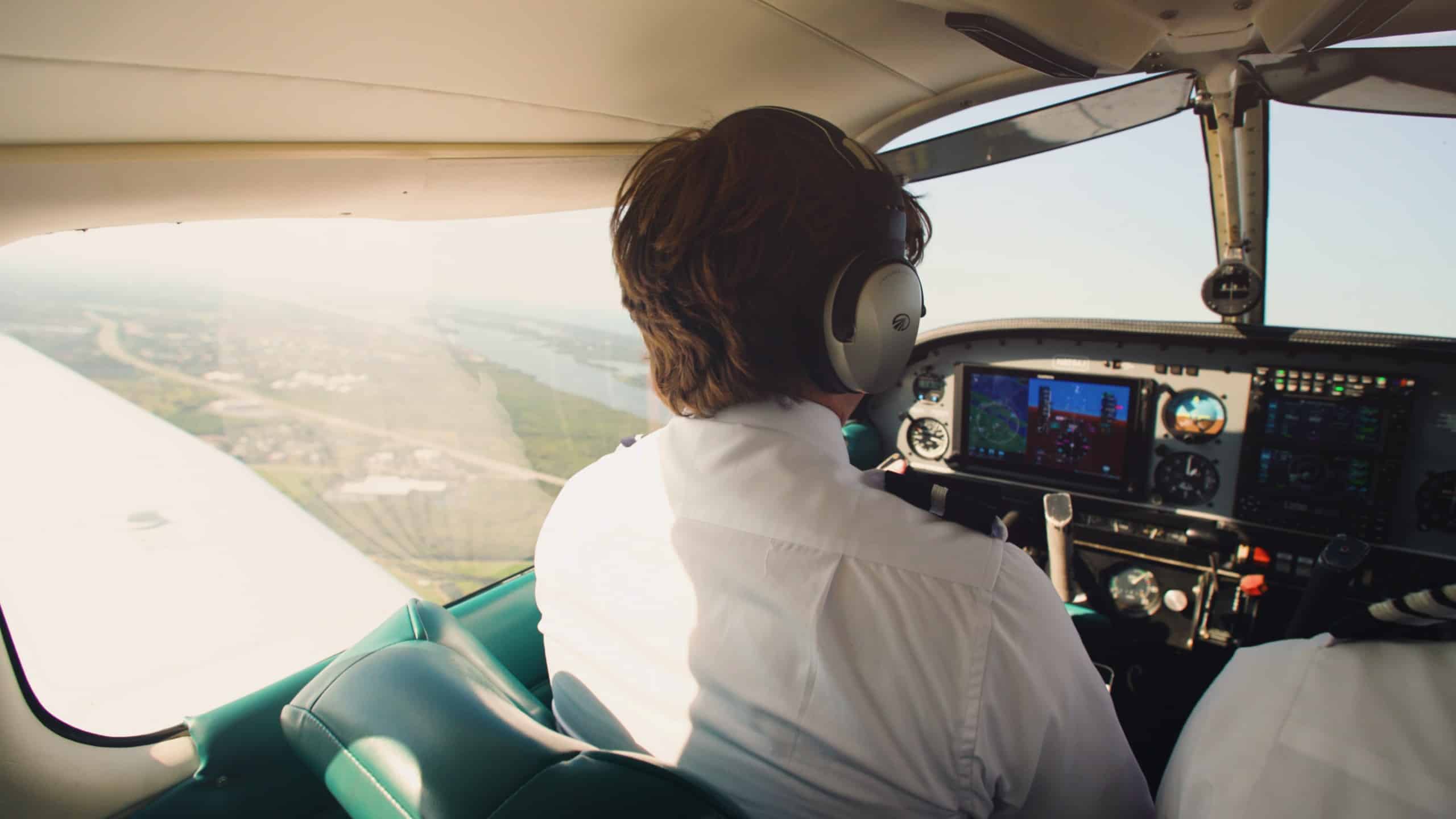 A pilot in the cockpit of a small airplane