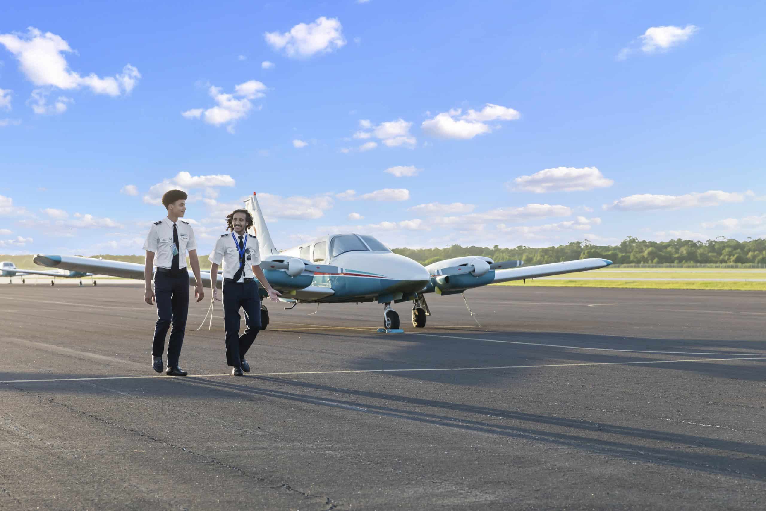 Two pilots walking on the tarmac with a Paris Air small airplane behind them
