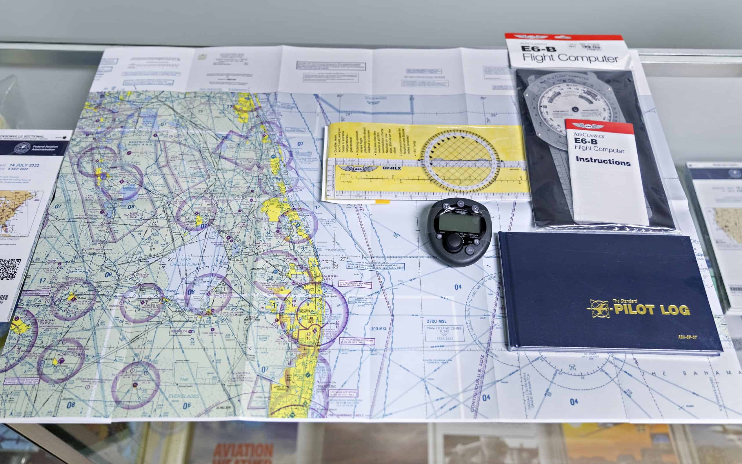 Pilot's logbook and instruments on a navigation map